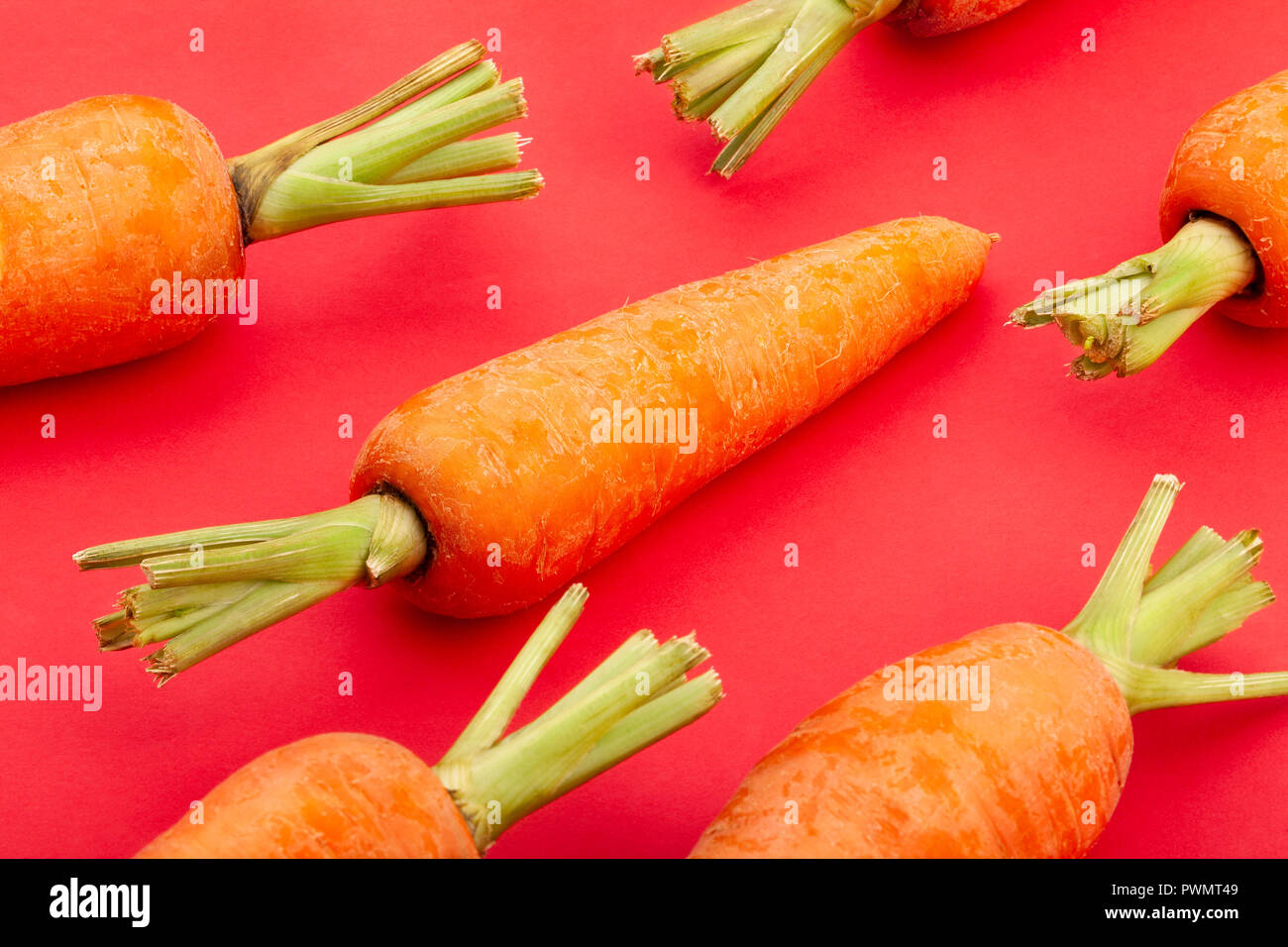 Le carote su sfondo rosso Foto Stock