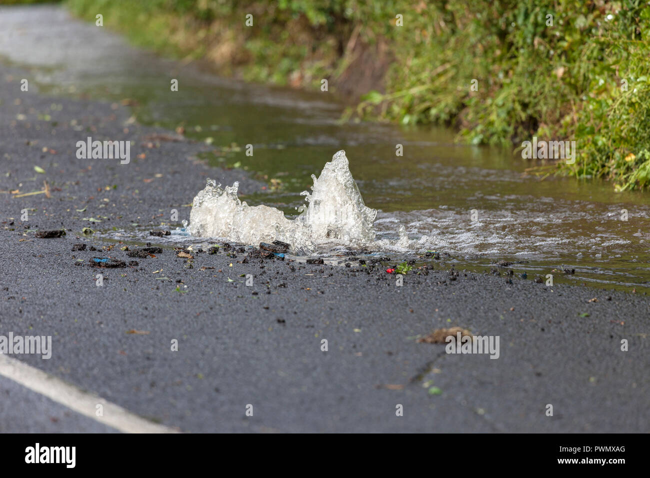 L'acqua sgorga da una raffica di acqua nella principale strada, County Durham, Regno Unito Foto Stock
