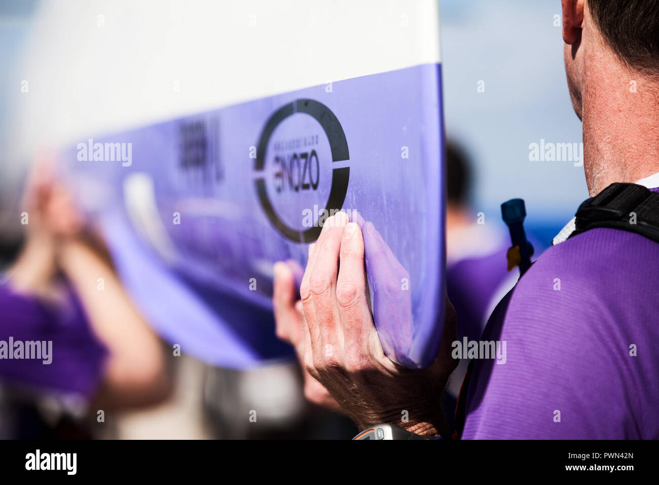 Gli uomini il sollevamento ed il trasporto di un dragon boat Foto Stock