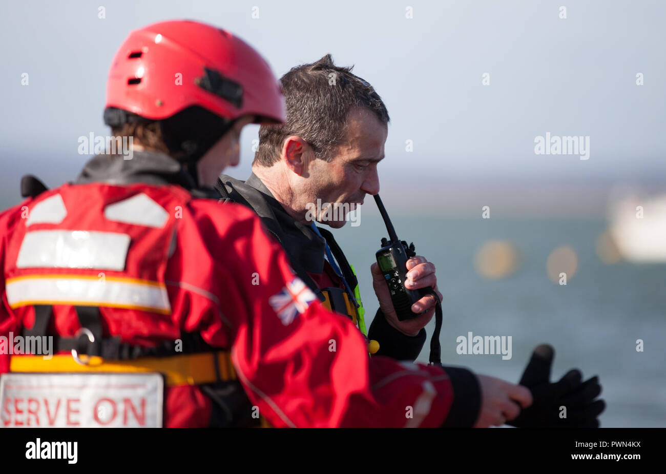 Due guardie costiere discussione permanente di lavoro Foto Stock