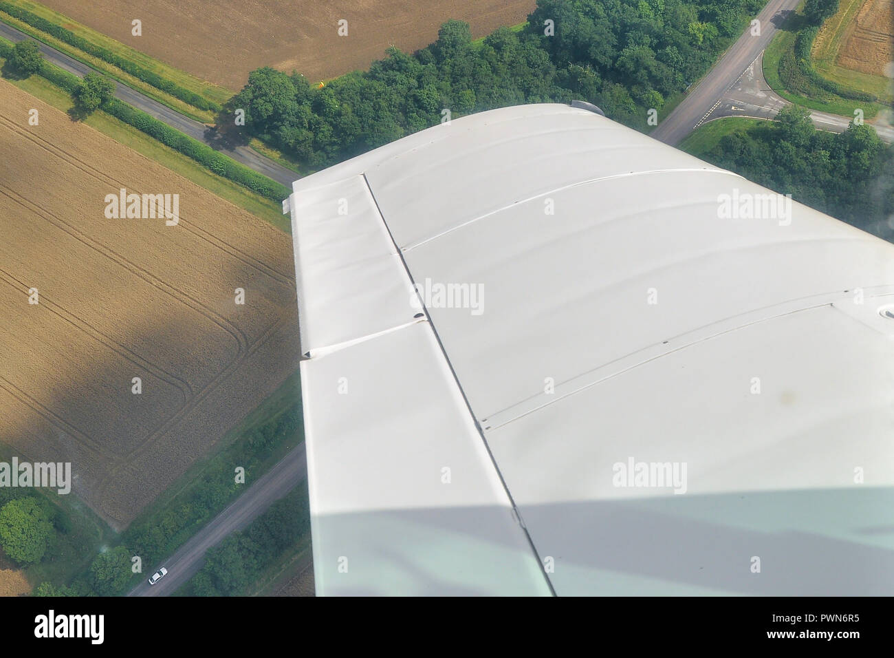 Ala di un piano girando intorno ad un angolo arancione posto del marcatore in un campo durante una gara dell'aria. Prova di navigazione. Air racing circuito indicatore di percorso. Campi Foto Stock