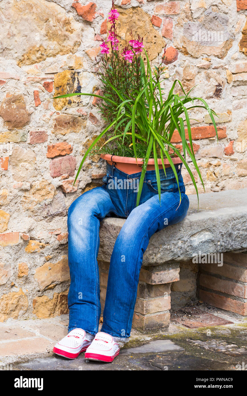 Upcycling - old jeans seduta sul banco di prova usato per coltivare fiori in Toscana, Italia nel mese di maggio Foto Stock