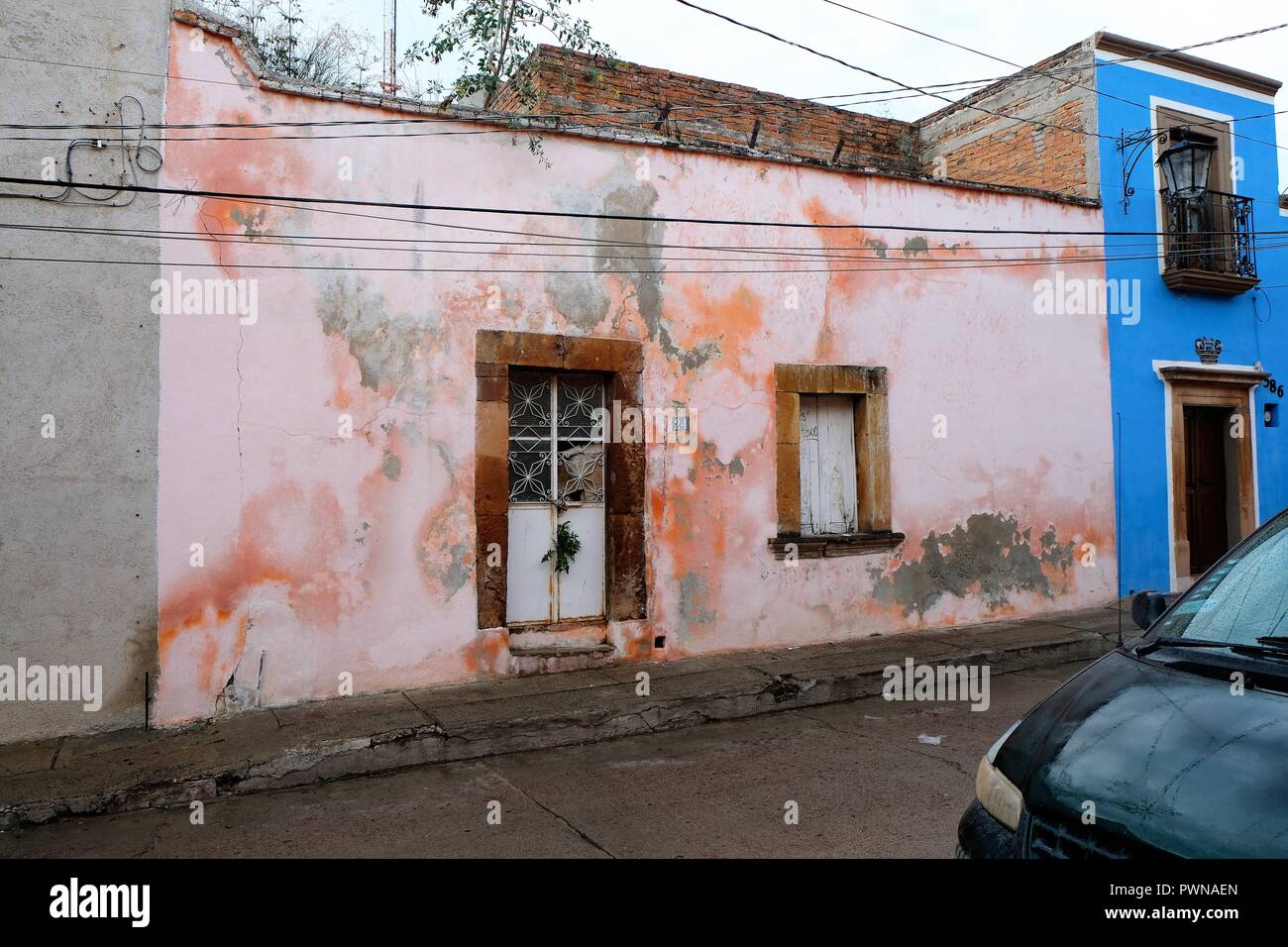 Esterno della casa abbandonata in Lagos de Moreno, Jalisco, Messico; lavati con pareti di vetro e le erbacce crescono fuori della porta anteriore. Foto Stock