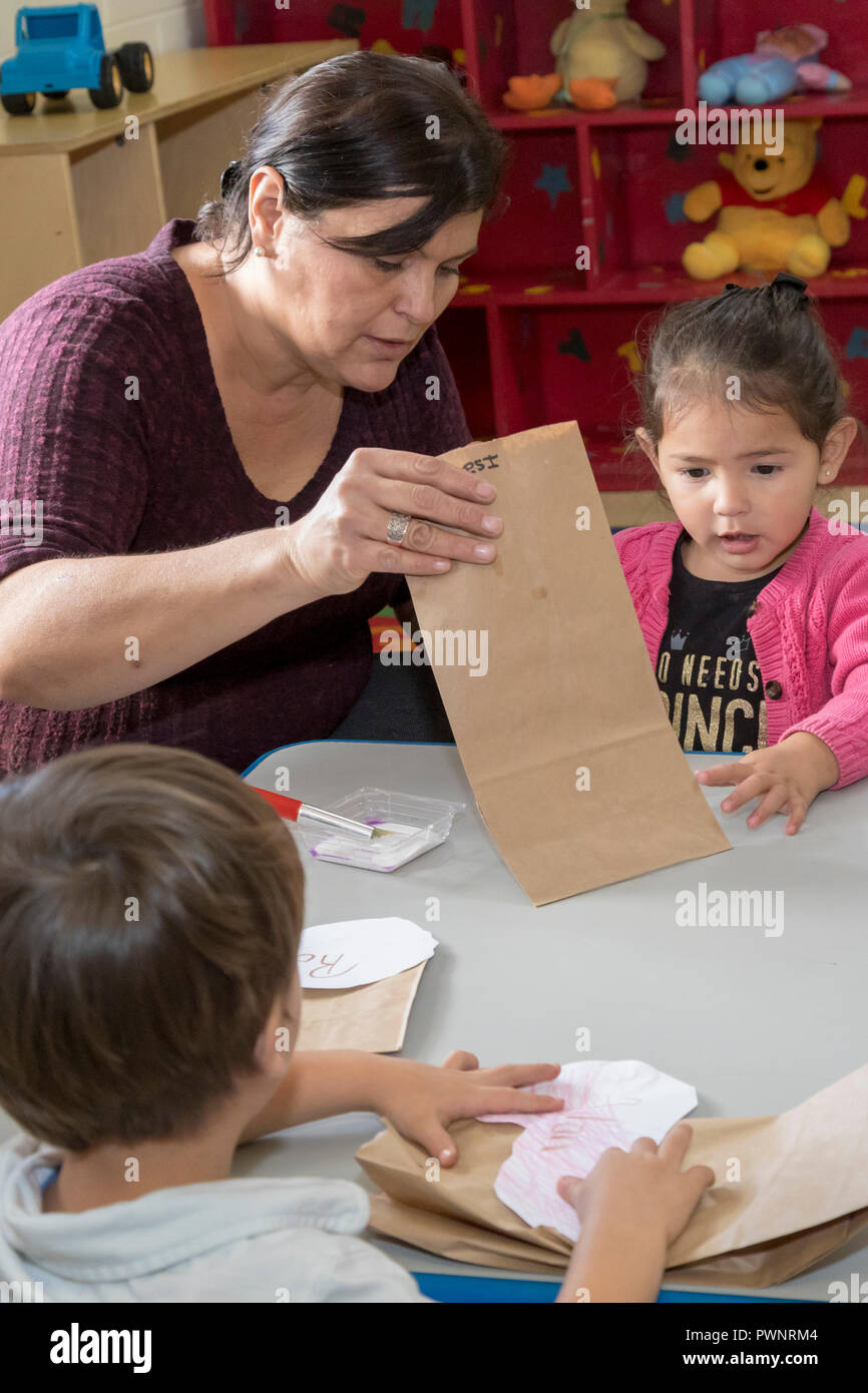 Alpine, Texas - Mari Rodriguez aiuta i bambini con un progetto artistico in due anni aula presso la comunità alpina centro. Il centro è un missi Foto Stock