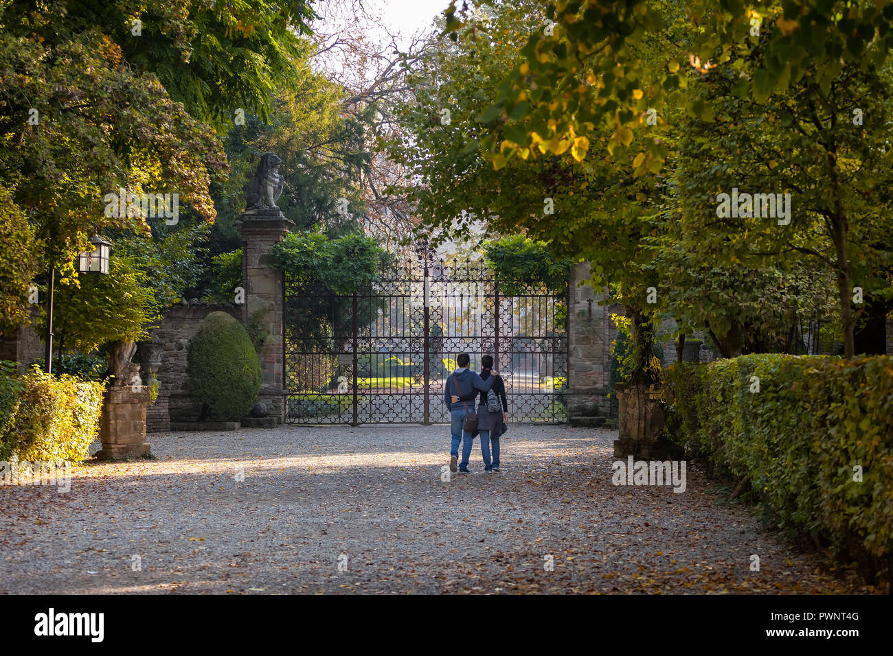 Coppia giovane a camminare nel mezzo di un autunno del percorso verso la porta del castello di Grazzano Visconti, Piacenza, Italia Foto Stock