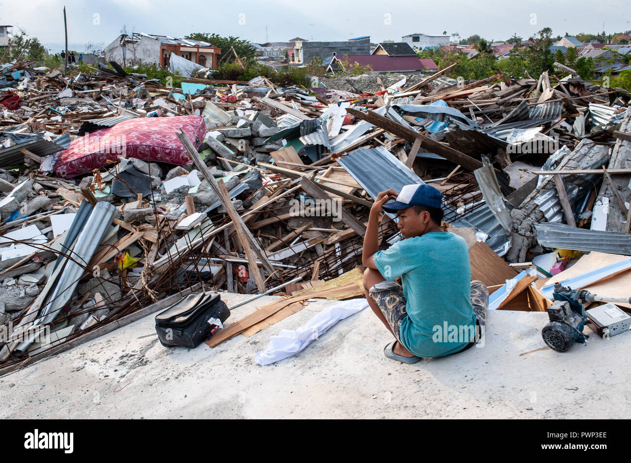 Sigi, Indonesia. Xvii oct, 2018. Un residente è visto situato accanto ai resti di edifici che sono state distrutte dal terremoto. Un mortale terremoto di magnitudo 7.5 grandezza e l'onda di maremoto ha causato da essa ha distrutto la città di Palu e gran parte dell'area di Sulawesi centrale. Secondo i funzionari, morte pedaggio dal devastante terremoto e tsunami sorge a 2088, circa 5000 persone negli ospedali sono gravemente feriti e circa 62.000 persone sono state sfollate. Credito: SOPA Immagini limitata/Alamy Live News Foto Stock