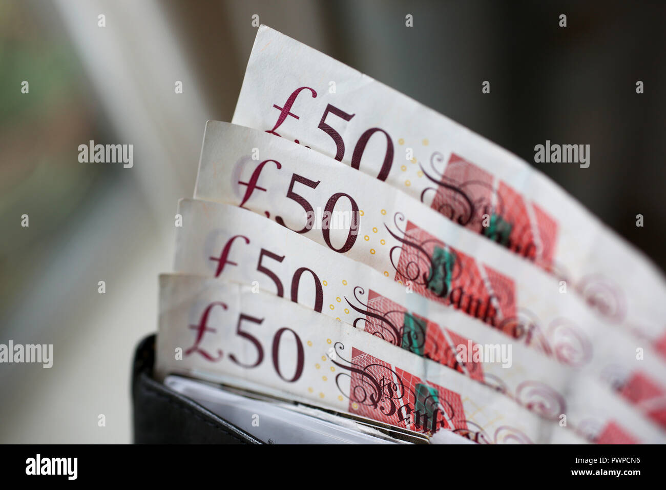 Una selezione di £50 note insieme a £10, £5 note in un portafoglio a Londra, Regno Unito. Foto Stock