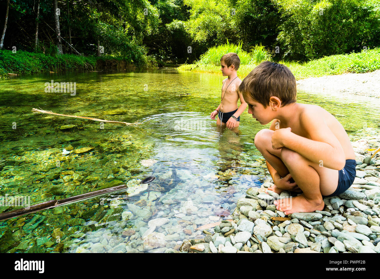 Due bambini di 6 e 8 anni a giocare nel fiume, Charlotteville, Tobago Trinidad e Tobago, West Indies, Sud America Foto Stock