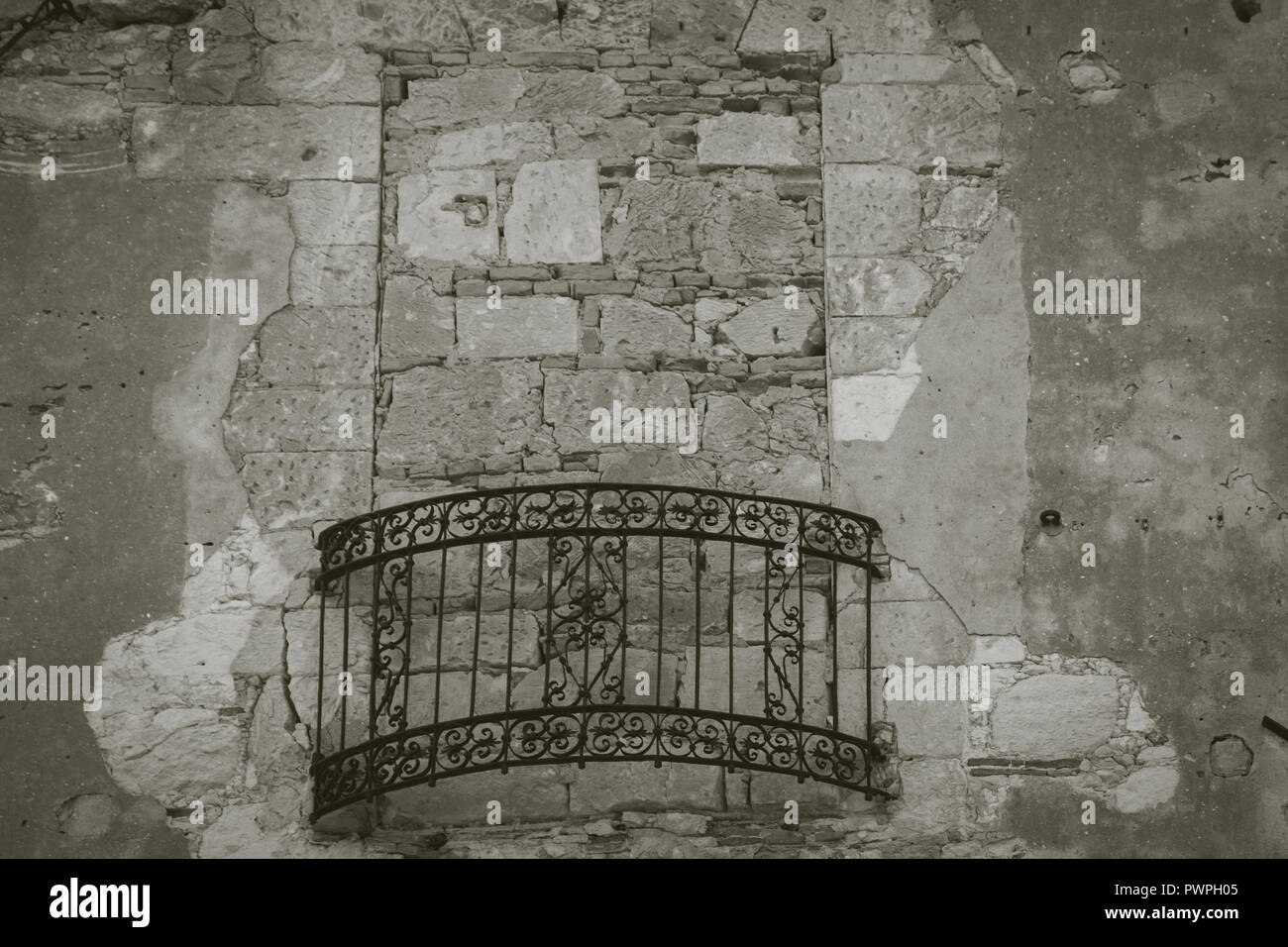 Finestra murata con ferro battuto balcone della vecchia casa nel quartiere del castello del centro storico di Cagliari, Sardegna, Italia. Immagine in bianco e nero e w Foto Stock