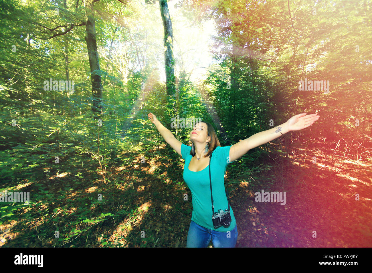 Giovane donna nella foresta con una telecamera. Foto Stock