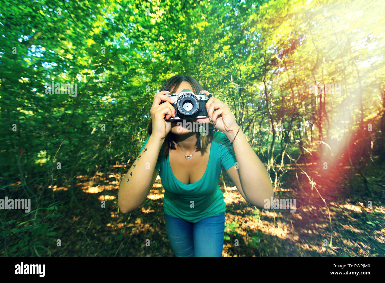 Giovane donna nella foresta con una telecamera. Foto Stock
