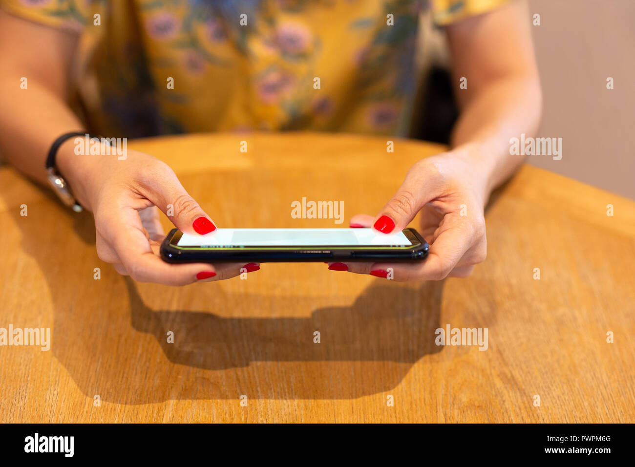Donna con colore rosso chiodo tramite telefono cellulare. Foto Stock