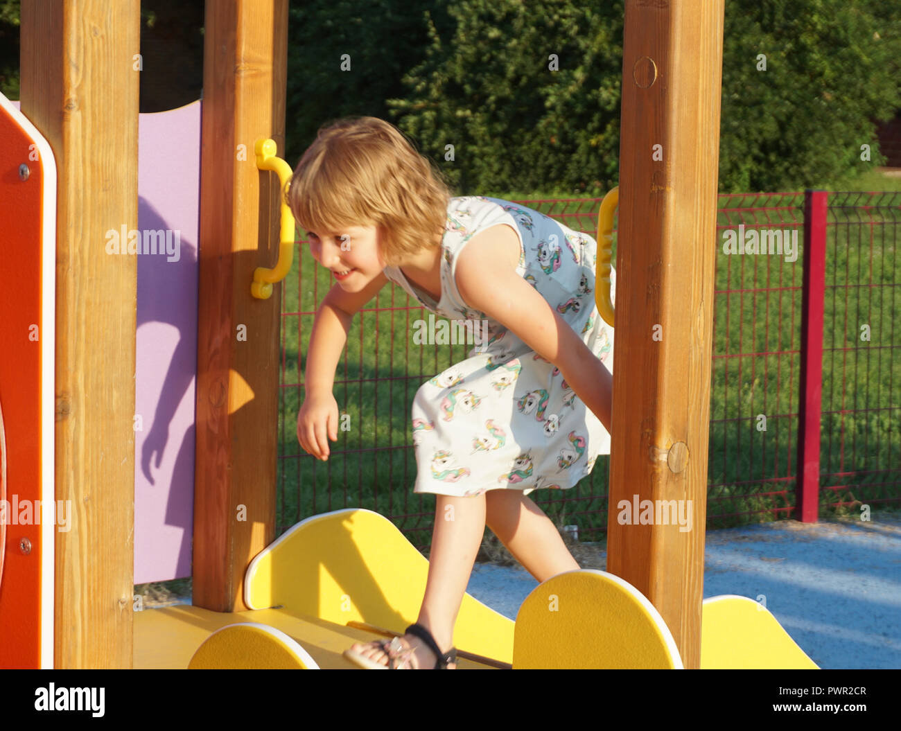 Una bambina su un parco giochi. Sviluppo del bambino attività su un parco giochi per bambini Foto Stock