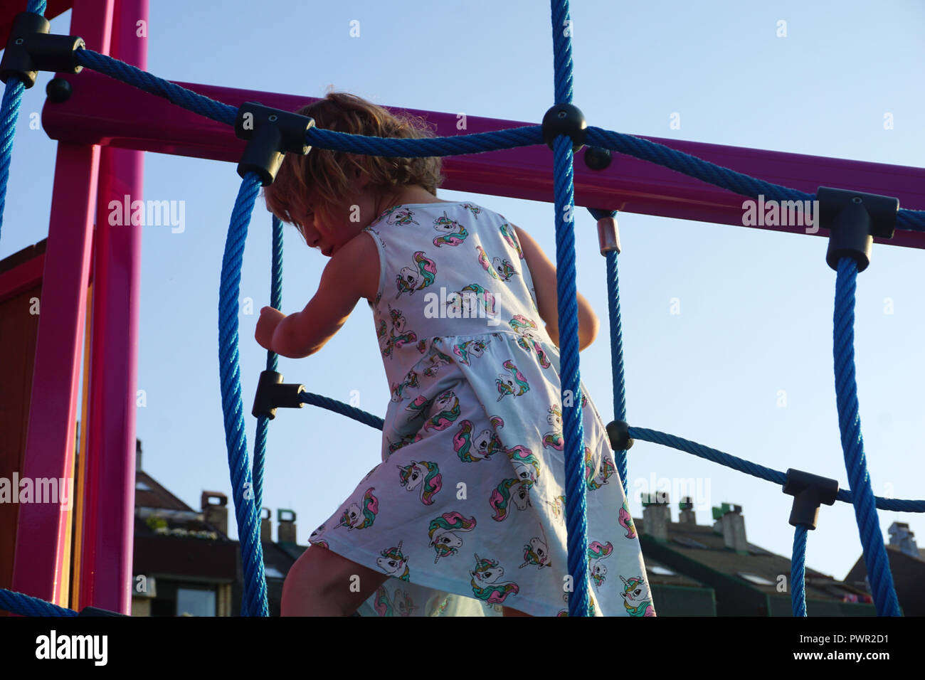 Attività di arrampicata sul parco giochi per bambini. Una bambina gioca su un parco giochi Foto Stock