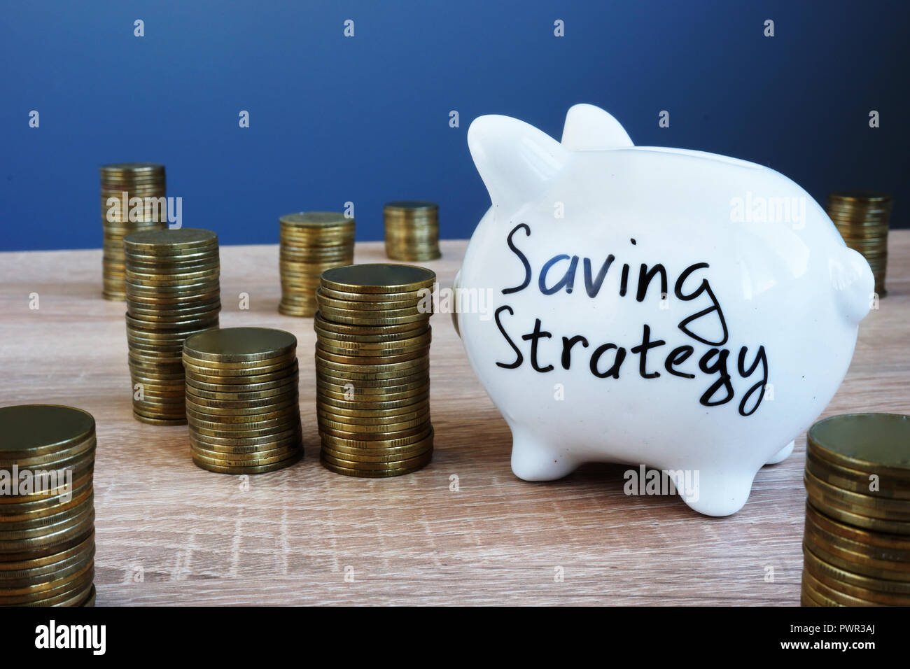 Strategie di risparmio scritto su un salvadanaio e denaro. Foto Stock