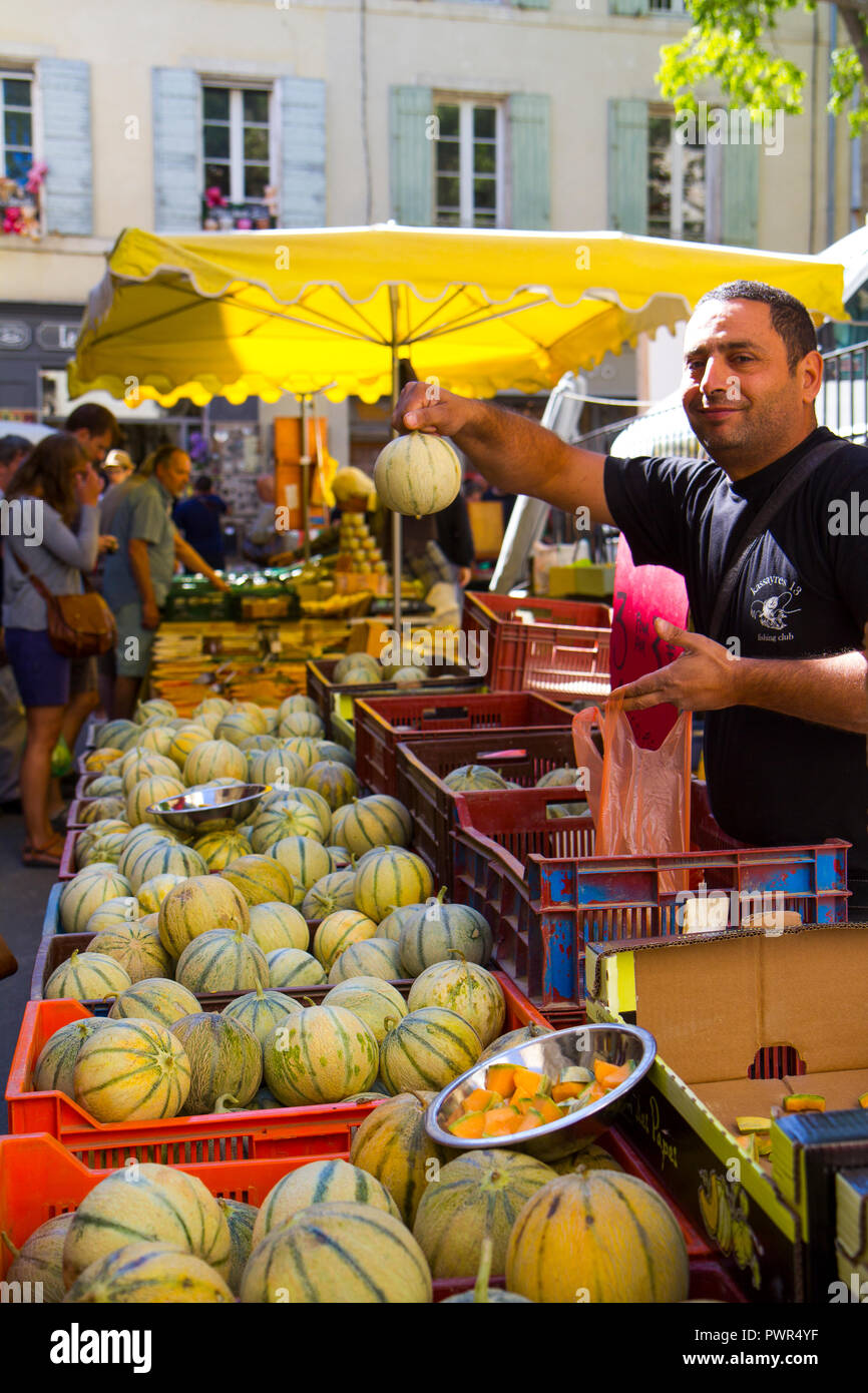 Un venditore a vendere melone meloni (Charentais) su un mercato nel sud della Francia Foto Stock