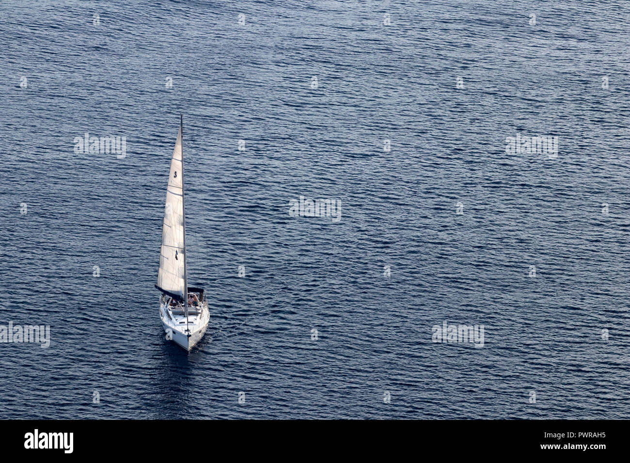 Smaill masted singolo yacht vele il mare Egeo, vicino all isola di Santorini, Grecia, agosto 2018, vista aerea. Foto Stock
