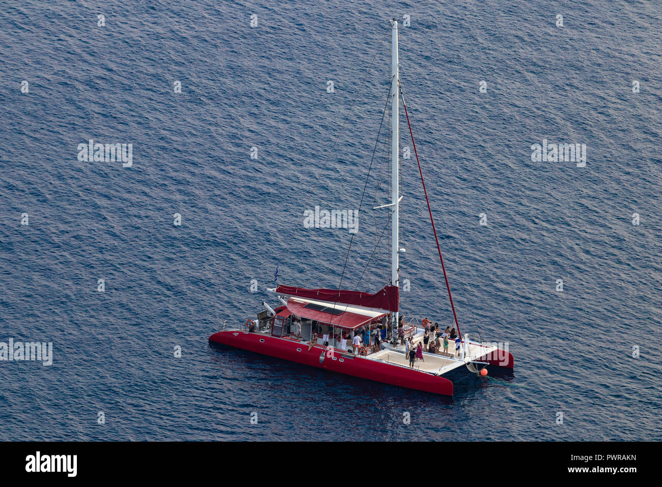 Rosso di lusso unico masted catamarano yacht vele il mare Egeo, vicino all isola di Santorini, Grecia, agosto 2018, vista aerea. Foto Stock