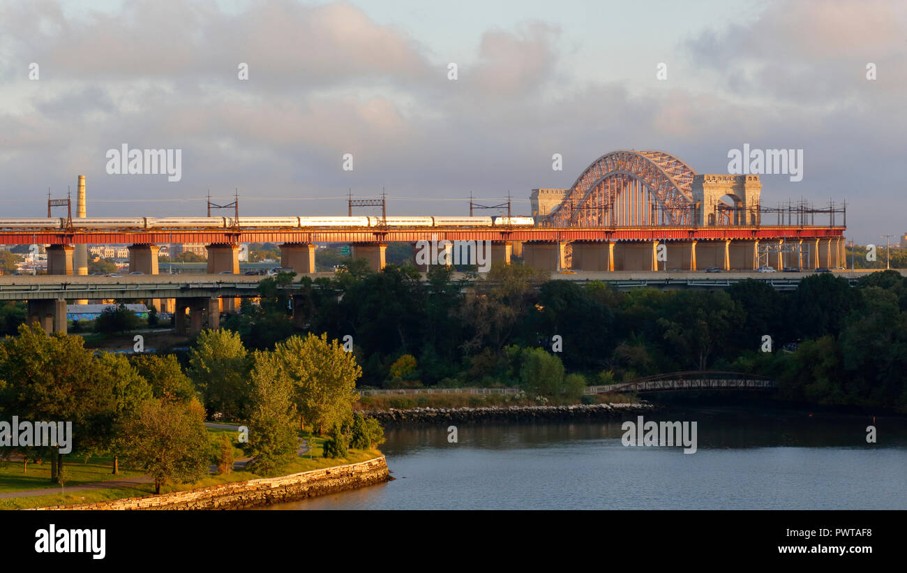 Un treno Amtrak in direzione sud si avvicina al ponte Hell Gate Bridge che collega Randalls Island con Queens a New York City Foto Stock