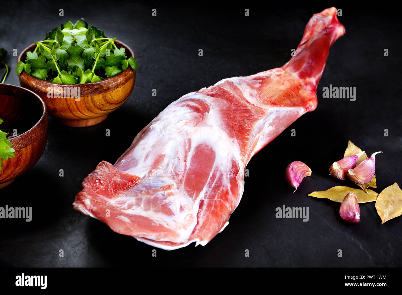 Fresco e carne cruda. La gamba di agnello non cotti , pronto per grill e barbecue sul nero ardesia sfondo Foto Stock