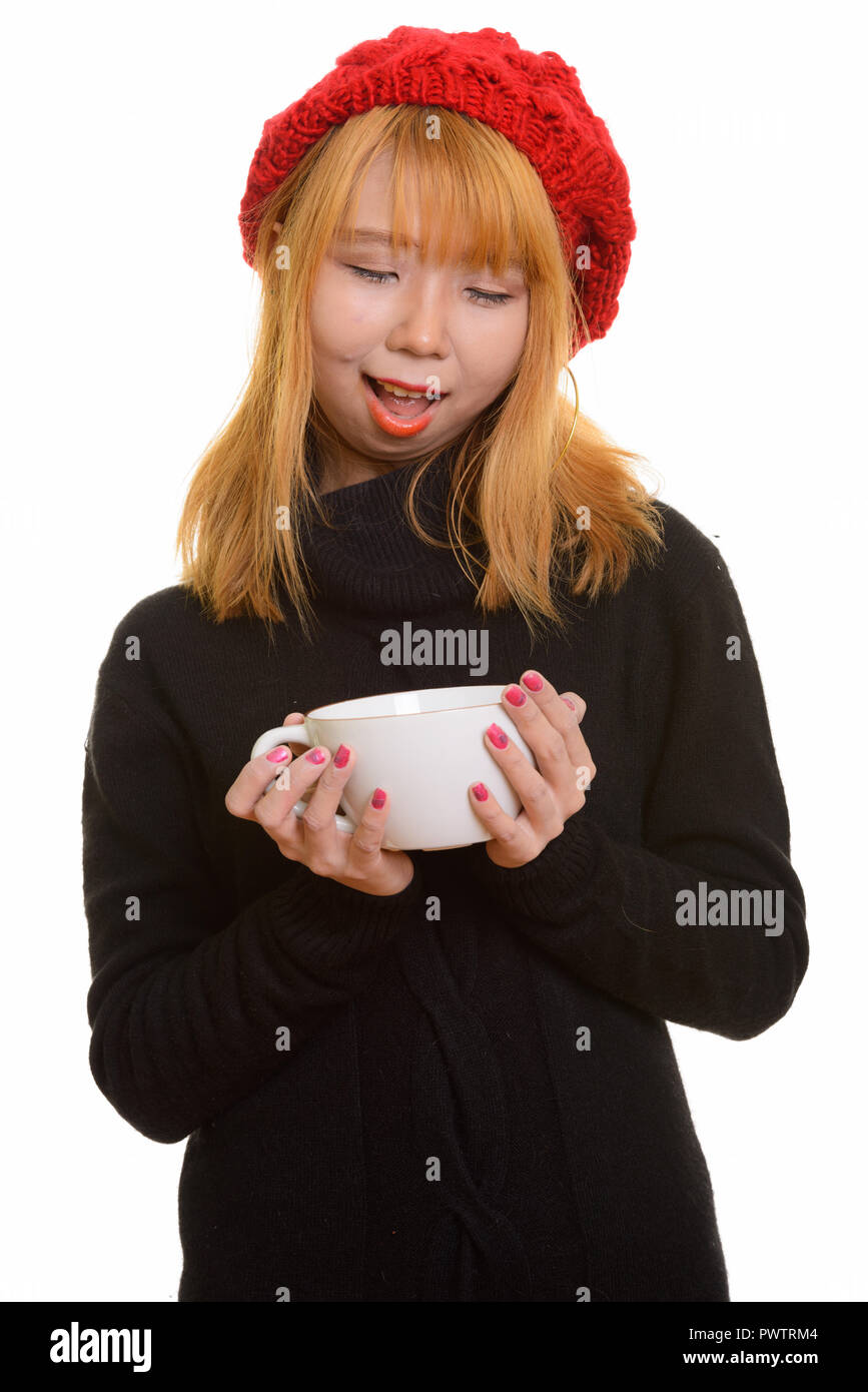 Felice giovane donna asiatica sorridere mentre holding e guardando a COF Foto Stock