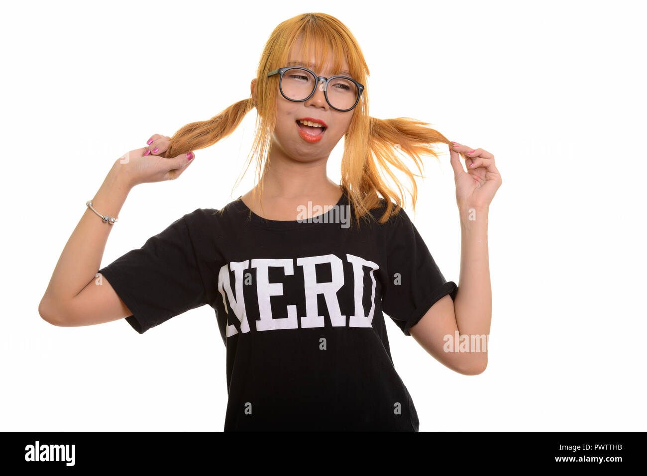 Giovani asiatici felice nerd donna sorridente e giocare con i suoi capelli w Foto Stock