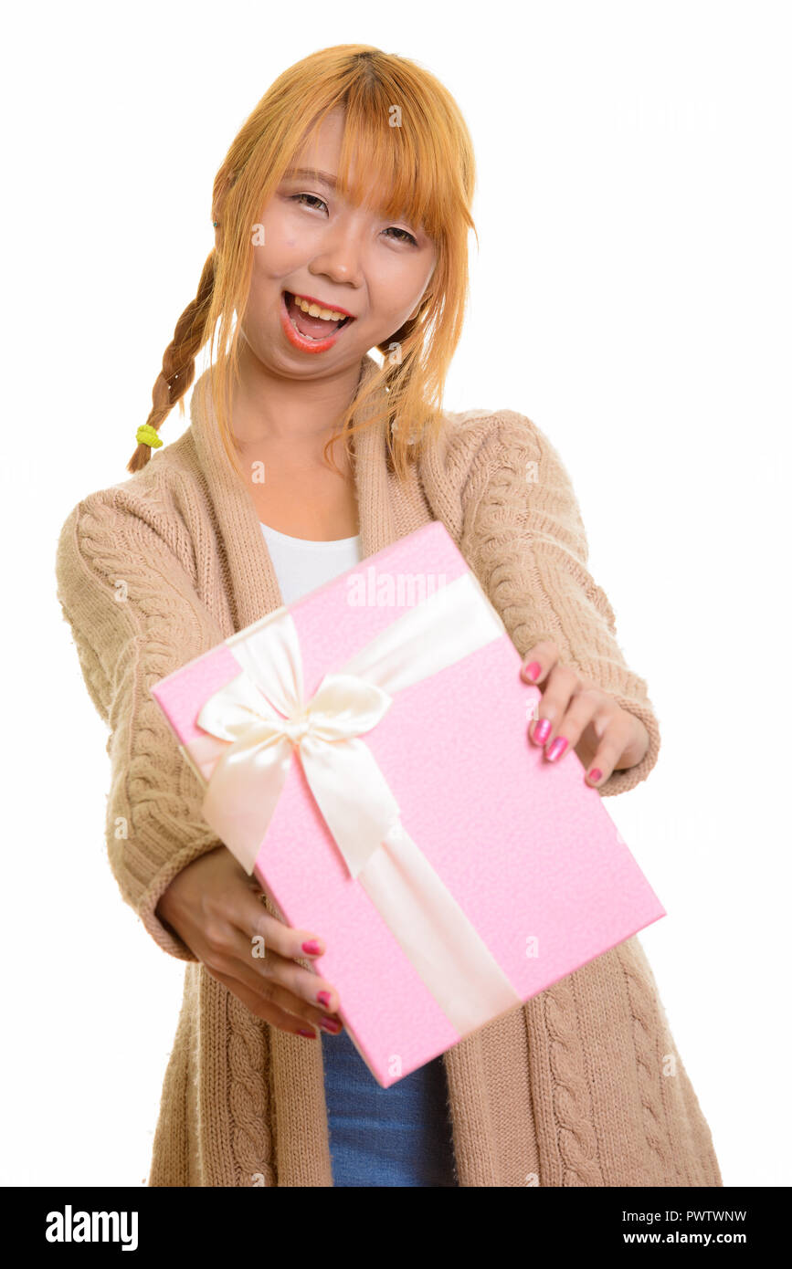 Felice giovane donna asiatica sorridente e dando confezione regalo Foto Stock