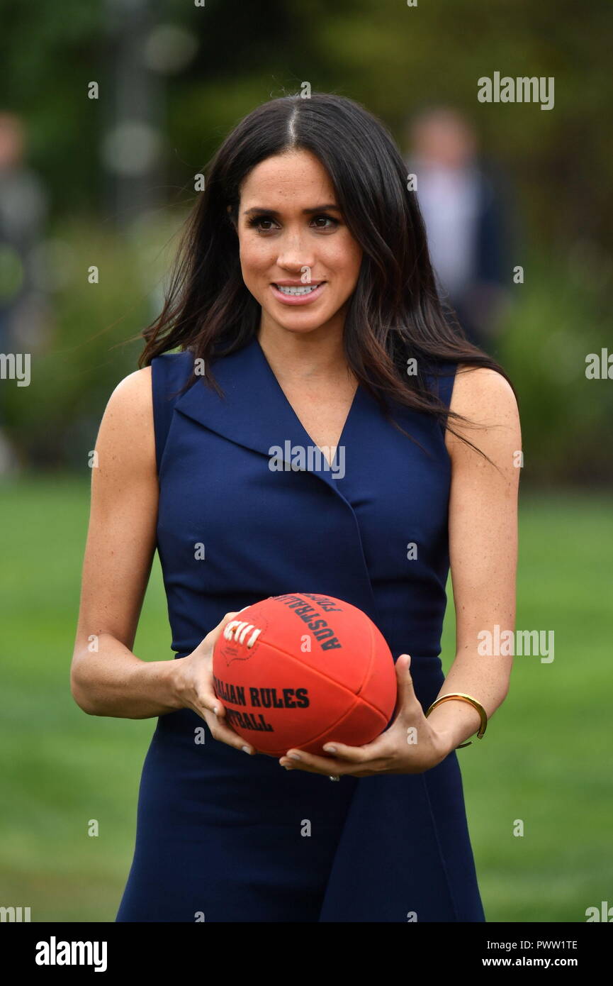 La Duchessa di Sussex con un Australian rules football durante una visita a Melbourne, il terzo giorno della coppia reale il tour in Australia. Foto Stock