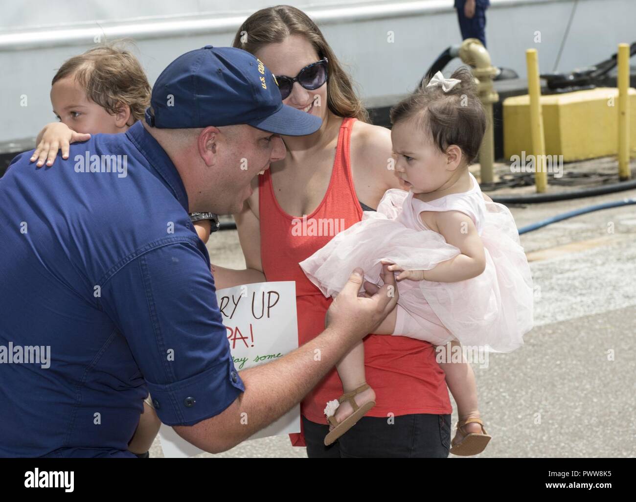 Un membro di equipaggio a bordo del guardacoste Venturous riunisce con la sua famiglia Sabato, 1 Luglio 2017 dopo il ritorno a casa a San Pietroburgo, in Florida. La taglierina restituito dopo un 60-giorno di formazione e di applicazione della legge patrol nel mid-Oceano Atlantico a sostegno dell'operazione Ocean Hunter. Foto Stock