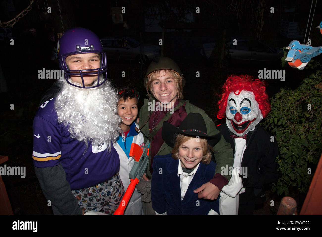 I ragazzi di Halloween costume per il trucco o il trattamento in clown, cowboy e bianco barbuto Santa Claus in Minnesota Viking uniforme. St Paul Minnesota MN USA Foto Stock