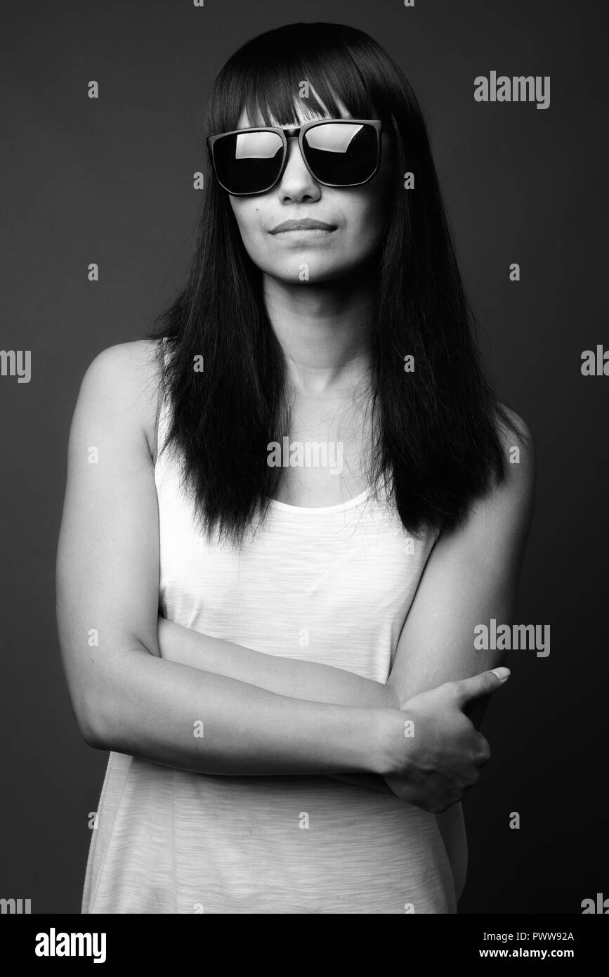 Giovane donna asiatica contro uno sfondo grigio in bianco e nero Foto Stock
