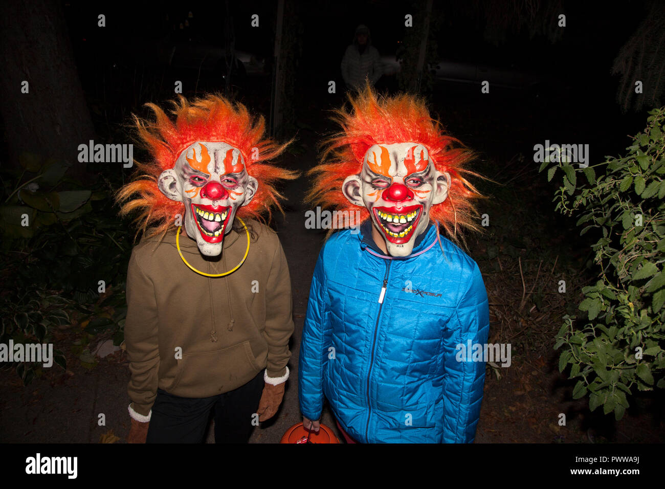 Coppia di ragazzi indossando spaventose maschere di clown fuori per una serata di trucchi o tratta. St Paul Minnesota MN USA Foto Stock