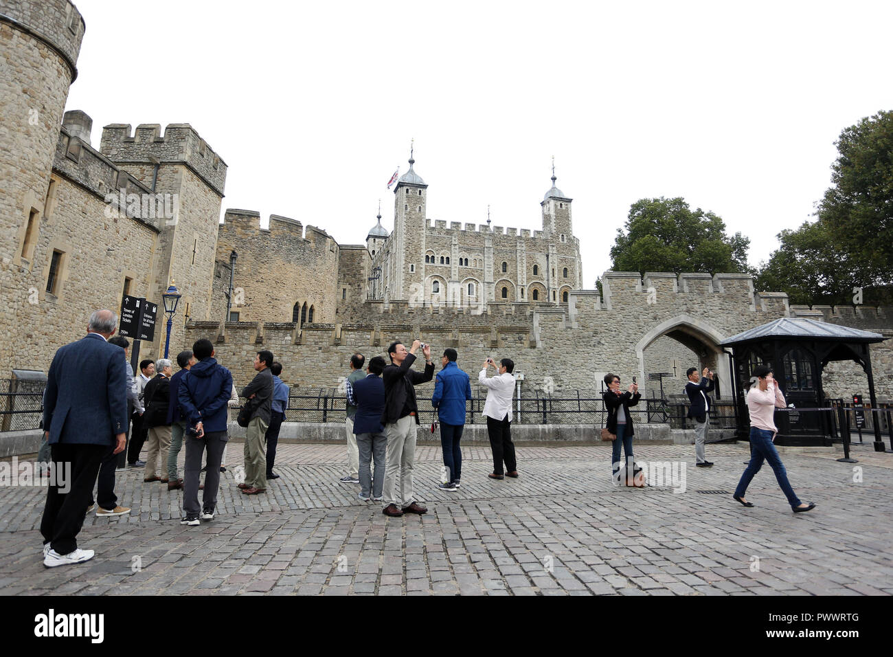I turisti scattano fotografie e selfies all'esterno della Torre di Londra a Londra storica pietra miliare e di attrazione turistica di Londra, Regno Unito. Foto Stock