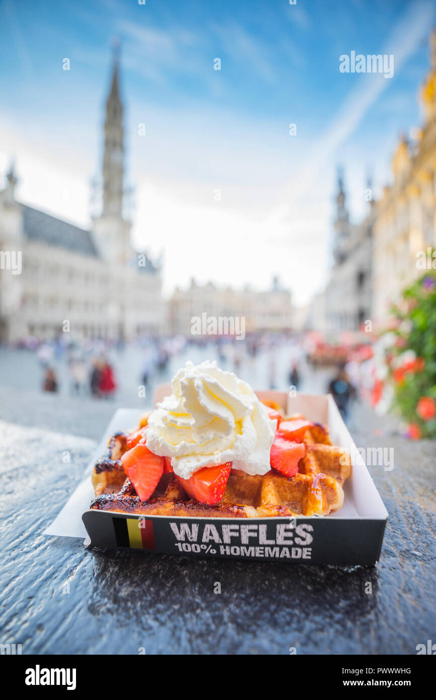 Tradizionale i waffle belgi con fragole e panna vicino alla Grand Place, la sfocatura sullo sfondo Foto Stock