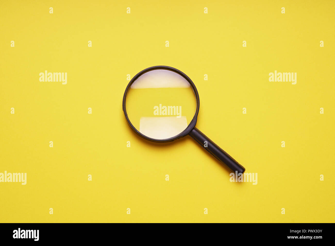 Lente di ingrandimento lente di ingrandimento Loupe simbolo di ricerca su sfondo giallo con spazio di copia Foto Stock