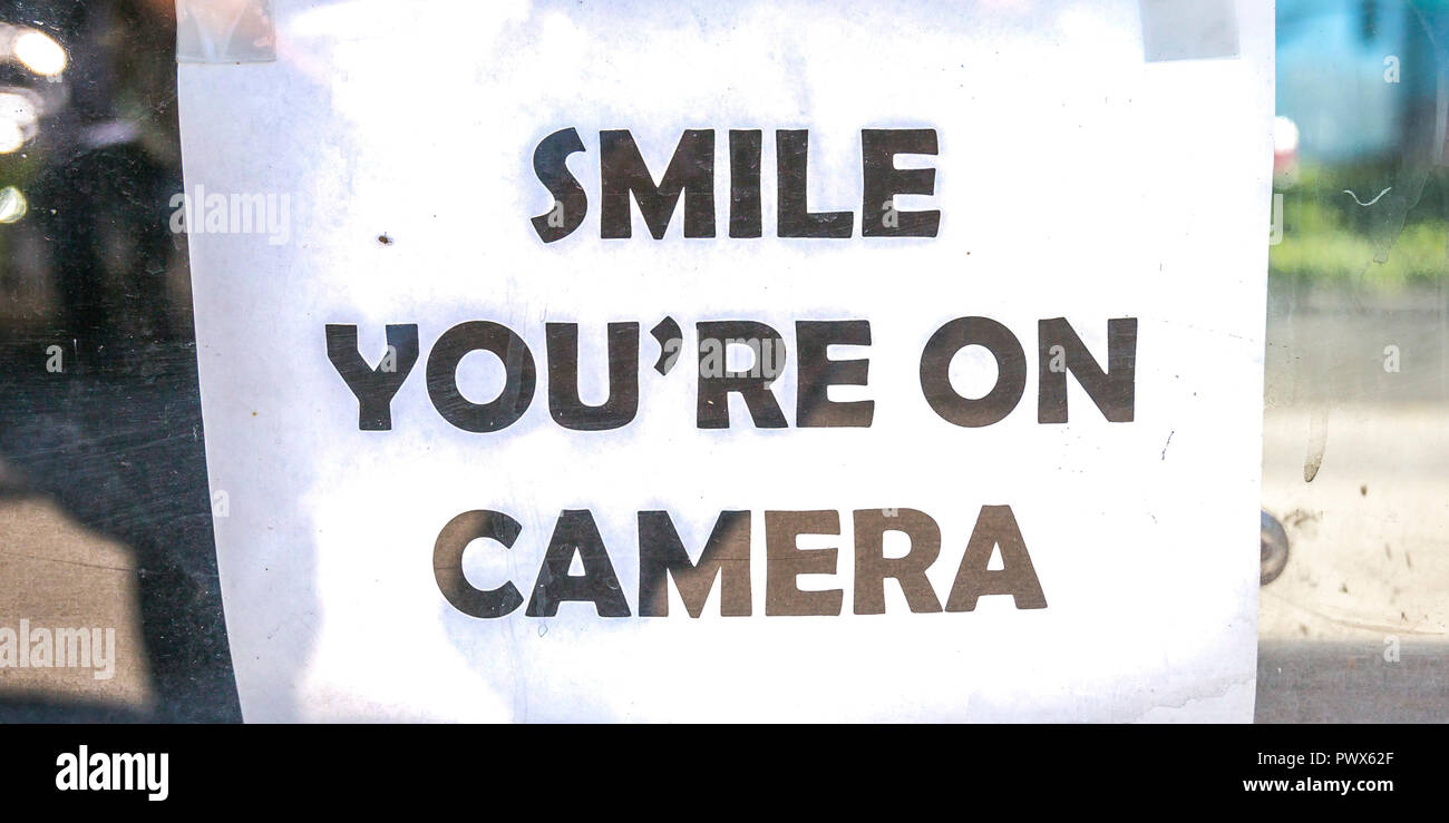 Smile youre sul segno della telecamera su una finestra di vetro Foto Stock