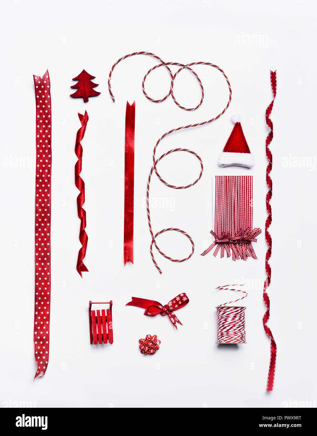 Natale Rosso nastri e fiocchi e decorazione per la decorazione e la confezione regalo e confezionamento su sfondo bianco, vista dall'alto, laici piatta Foto Stock