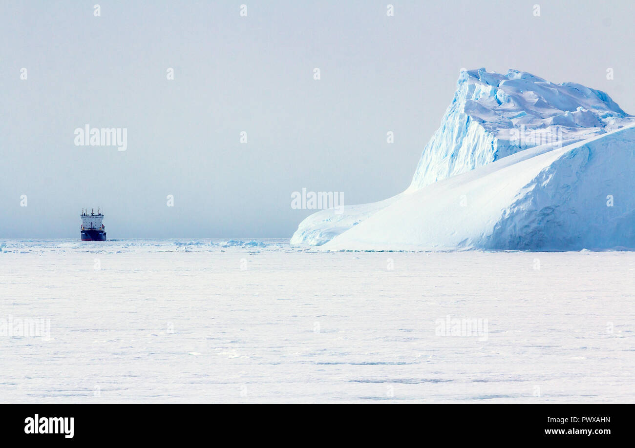 Iceberg galleggia sull'acqua aperto. È possibile vedere la parte subacquea di esso e il ghiaccio floes vicino ad essa. Antartico. Foto Stock