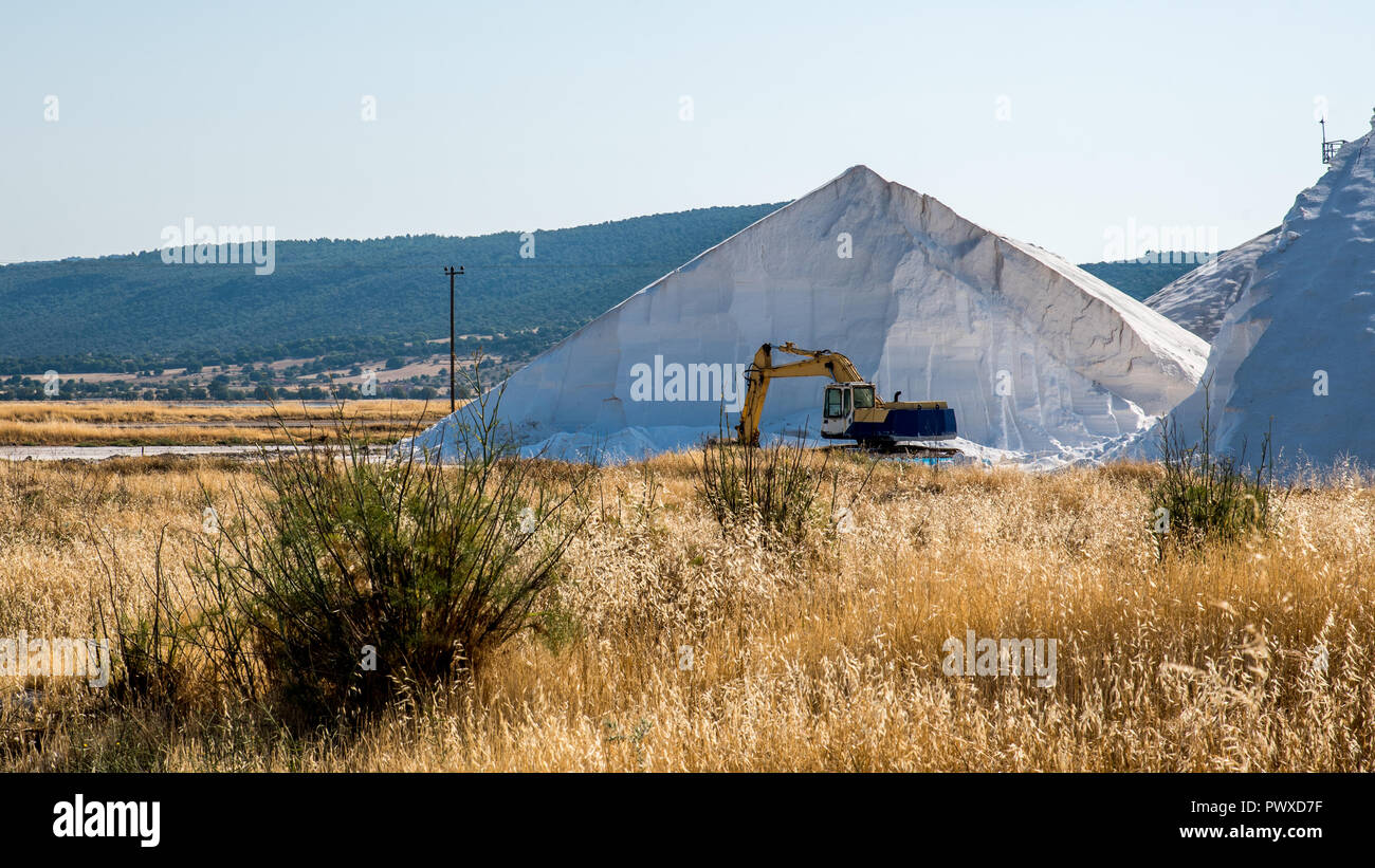 Pala di alimentazione macchinari di fronte a una grande montagna di sale Foto Stock