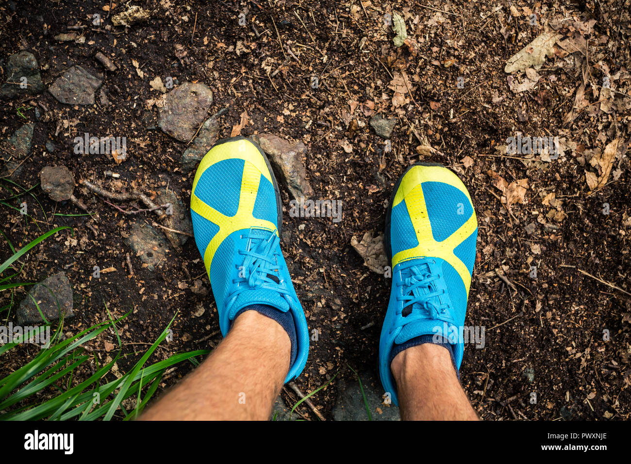 Trail runner guardando giù alla calzatura sportiva, di funzionamento e di formazione in natura. L'uomo runner che lavora fuori all'aperto in natura. Foto Stock