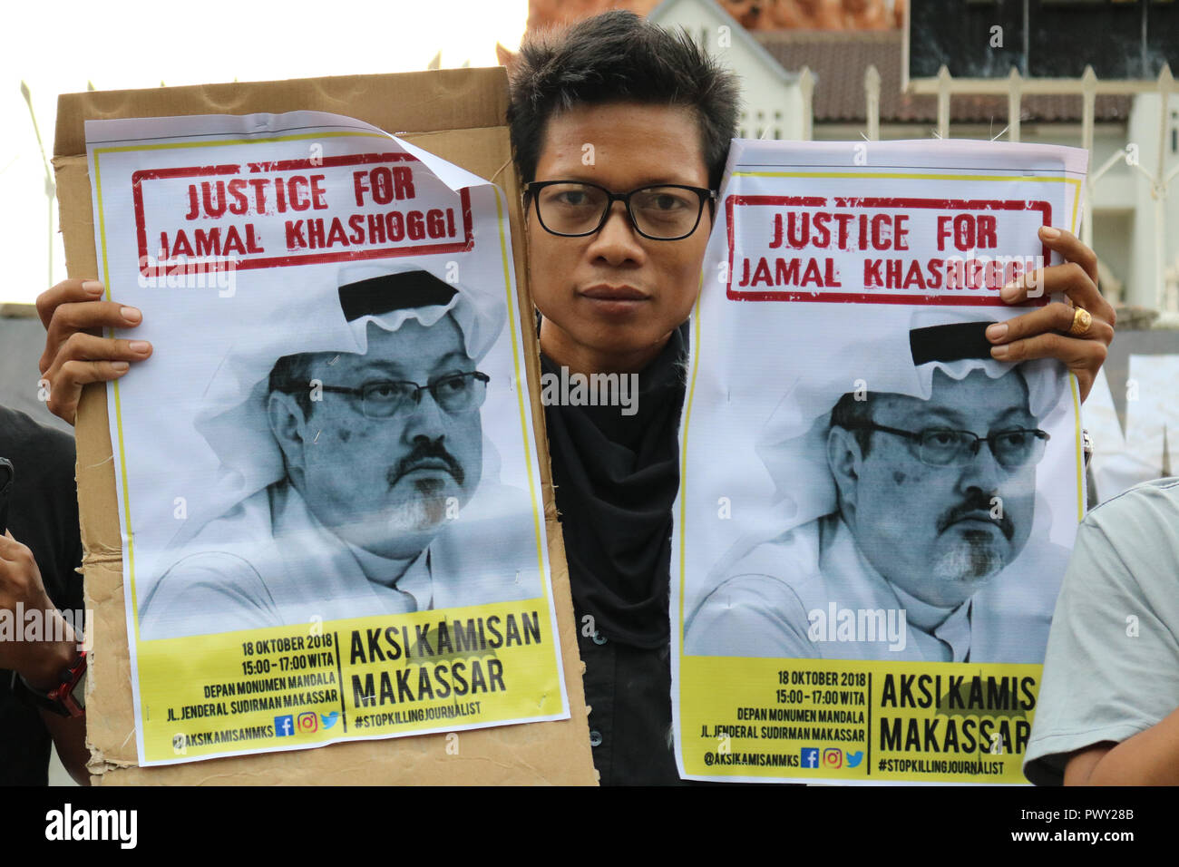 Makassar, Indonesia. 18 ott 2018. Un attivista umanitario tiene un poster con immagine di Jamal Khashoggi dimostrando di fronte al monumento del mandala, Makassar. Jamal Khashoggi, un Saudi Arabian giornalista che era presumibilmente uccisi e mutilati mentre al consolato saudita ad Istanbul in Turchia. La manifestazione organizzata a Makassar chiamato anche alla comunità internazionale di indagare a fondo l'assassinio del giornalista. Credito: Herwin Bahar/Alamy Live News Foto Stock