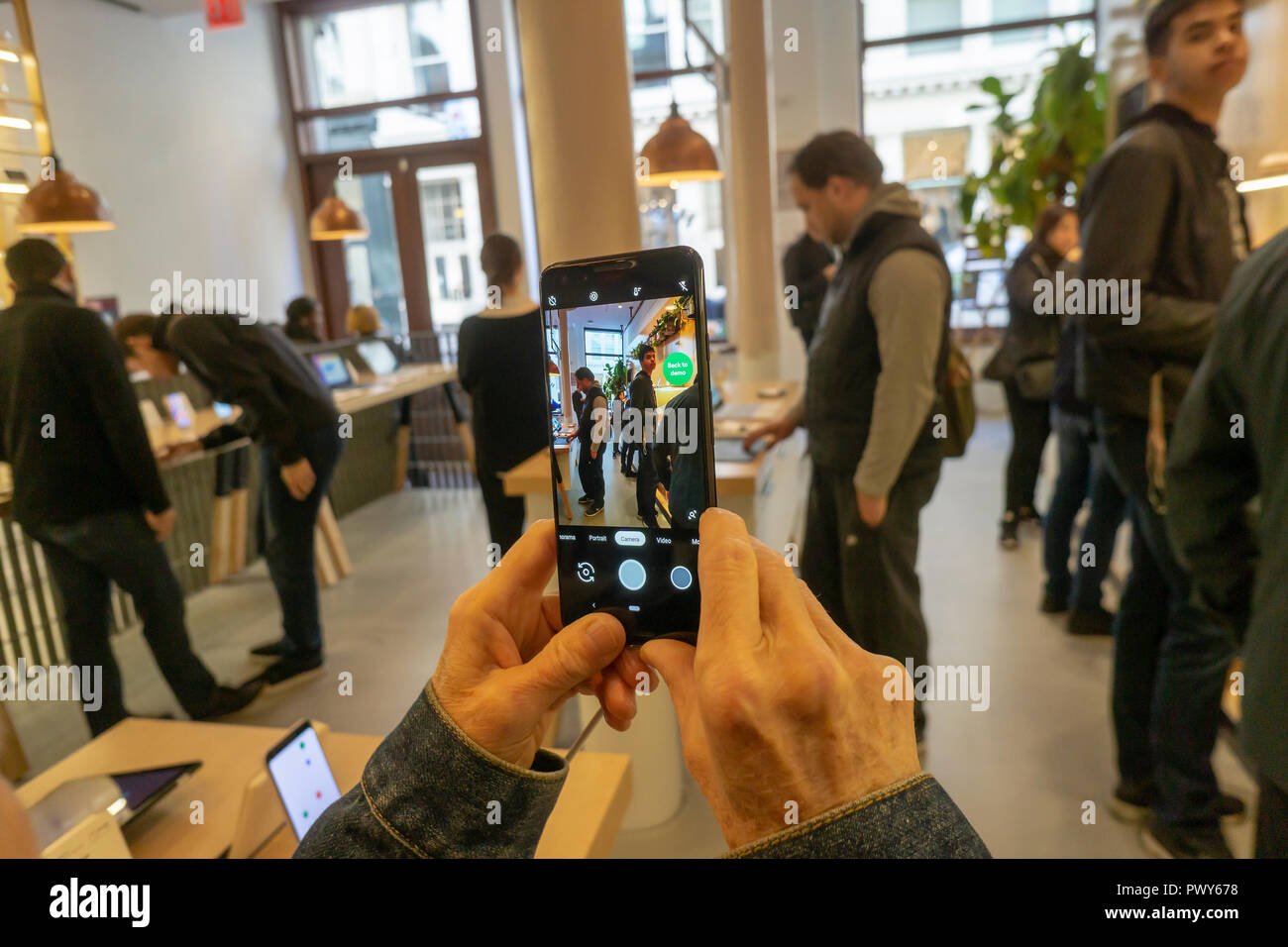 New York, New York, Stati Uniti d'America, 18 ottobre 2018. Un visitatore tenta di eseguire un pixel 3 smartphone in Google Hardware Store nel quartiere di Soho di New York sul suo giorno di inaugurazione, giovedì, 18 ottobre 2018. La Store visualizza una varietà di prodotti provenienti da Google come Google elettrodomestici e il nuovo pixel 3 smartphone e fornisce lo shopping esperienziale per i clienti. (© Richard B. Levine) Credito: Richard Levine/Alamy Live News Foto Stock