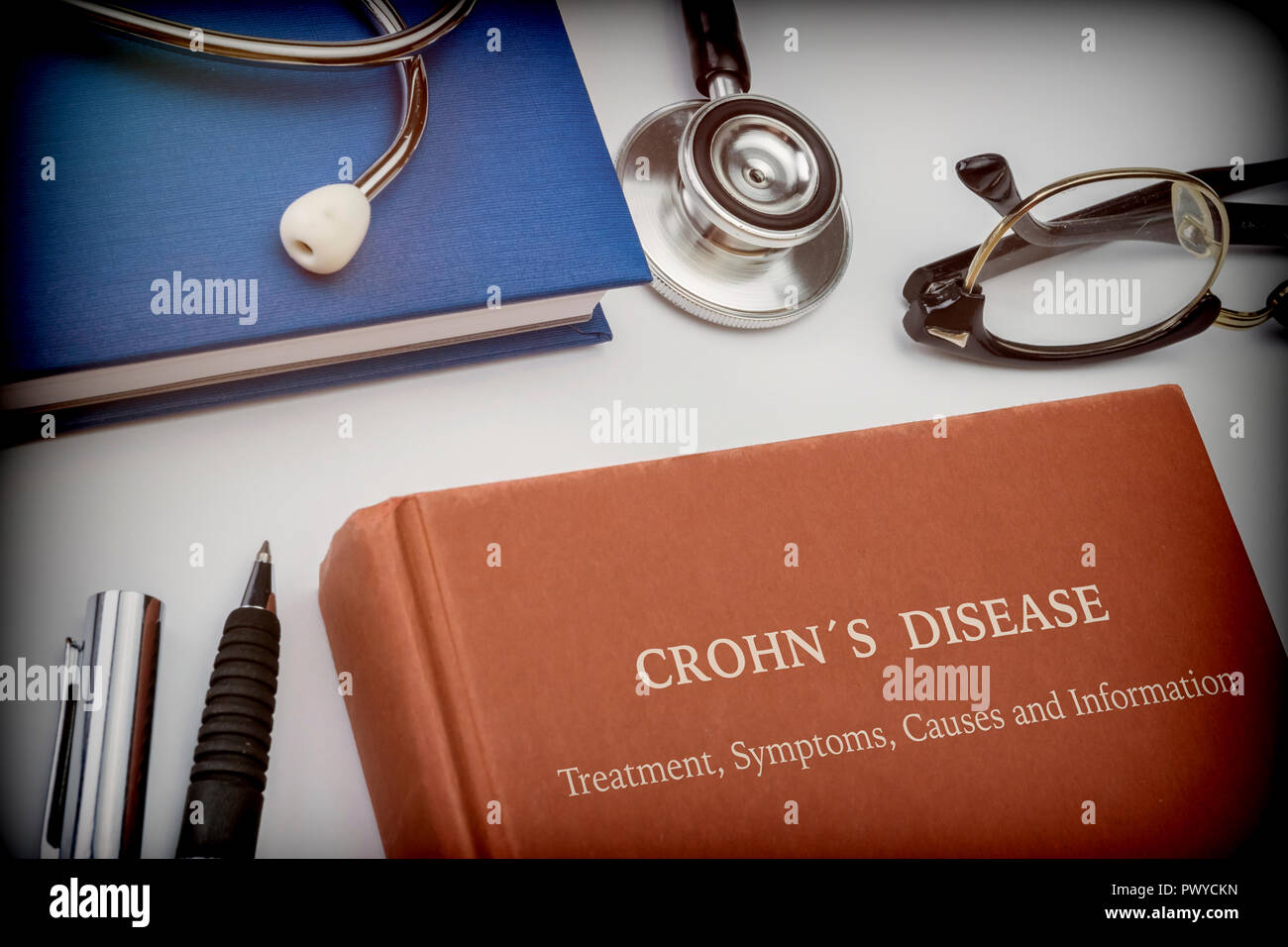 Libro intitolato il morbo di Crohn lungo con attrezzature mediche, immagine concettuale Foto Stock