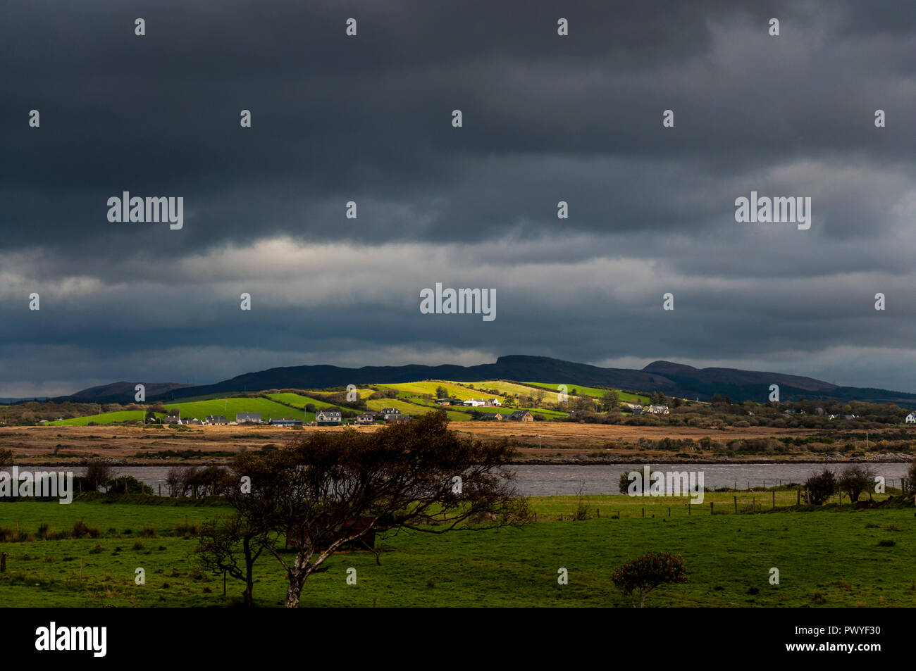 La luce del sole si rompe in su un ottuso tempestoso giorno sulla Wild Atlantic modo in County Donegal Foto Stock