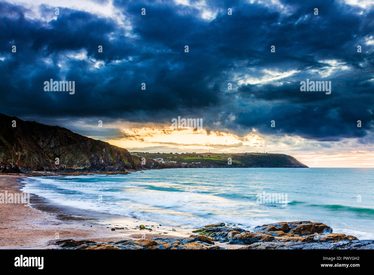 Tramonto sulla spiaggia di Tresaith in Ceredigion, Galles, guardando verso Aberporth. Foto Stock