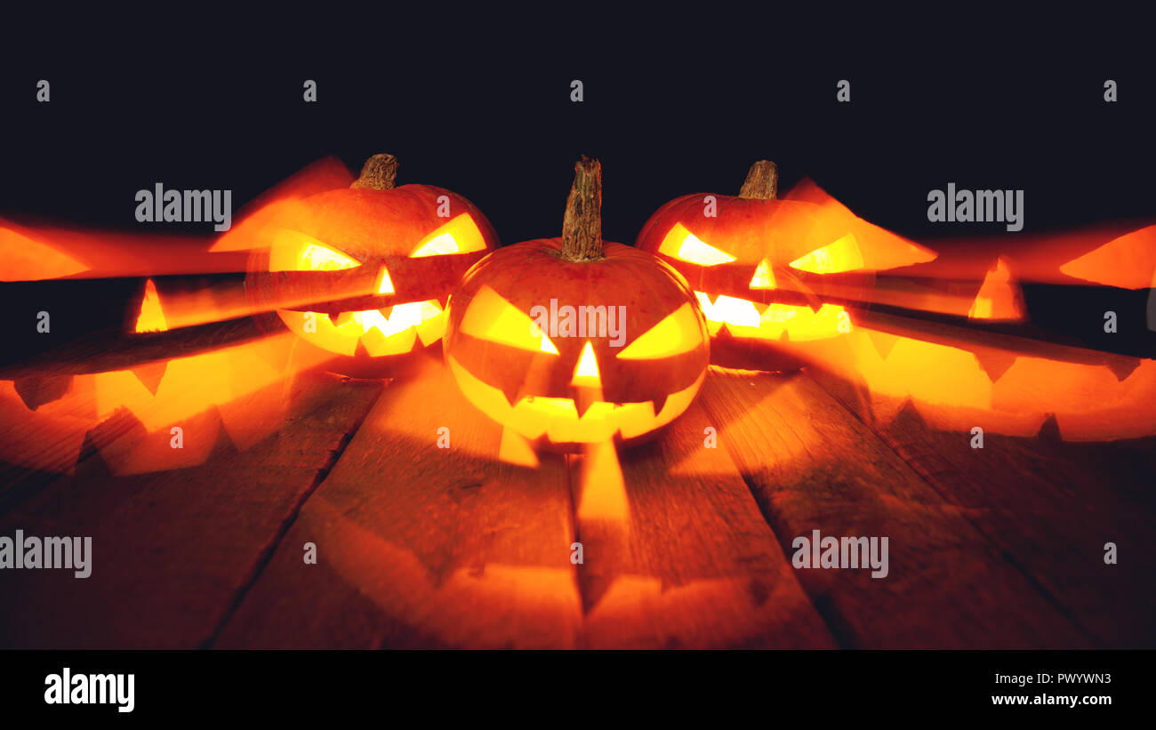 Tre Zucche di Halloween isolato su sfondo scuro Foto Stock