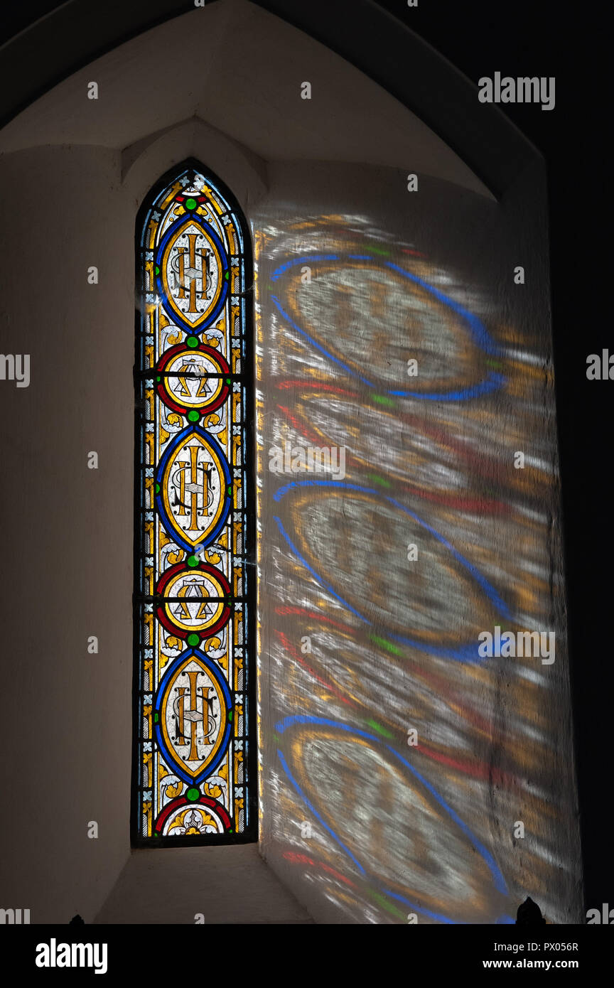 Il vetro macchiato Lancet finestra che mostra le lettere Greche Alfa e Omega e il monogramma IHS nel coro della chiesa della Beata Maria di Boyton. Foto Stock