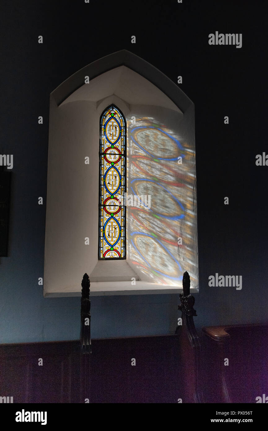Il vetro macchiato Lancet finestra che mostra le lettere Greche Alfa e Omega e il monogramma IHS nel coro della chiesa della Beata Maria di Boyton. Foto Stock