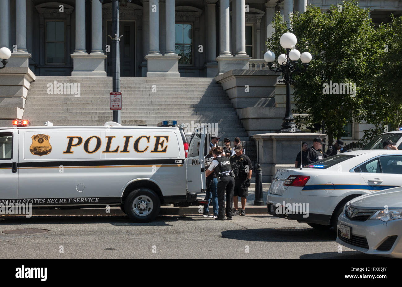La polizia arresta demonstrator (con Impeach Trump shirt) durante la conferma Kavanaugh protesta, Ott 1, 2018. Eisenhower Executive Office Bldg, DC in bg. Foto Stock