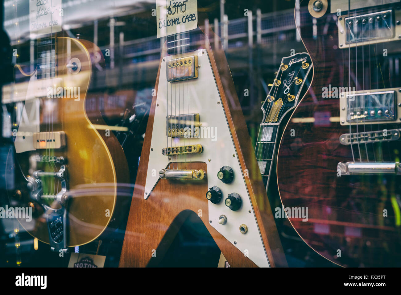 Hanks chitarre acustiche. Vecchio chitarre in vetrina del negozio, Tin Pan Alley / Denmark Street a Londra, Inghilterra. Vintage filtro applicato Foto Stock